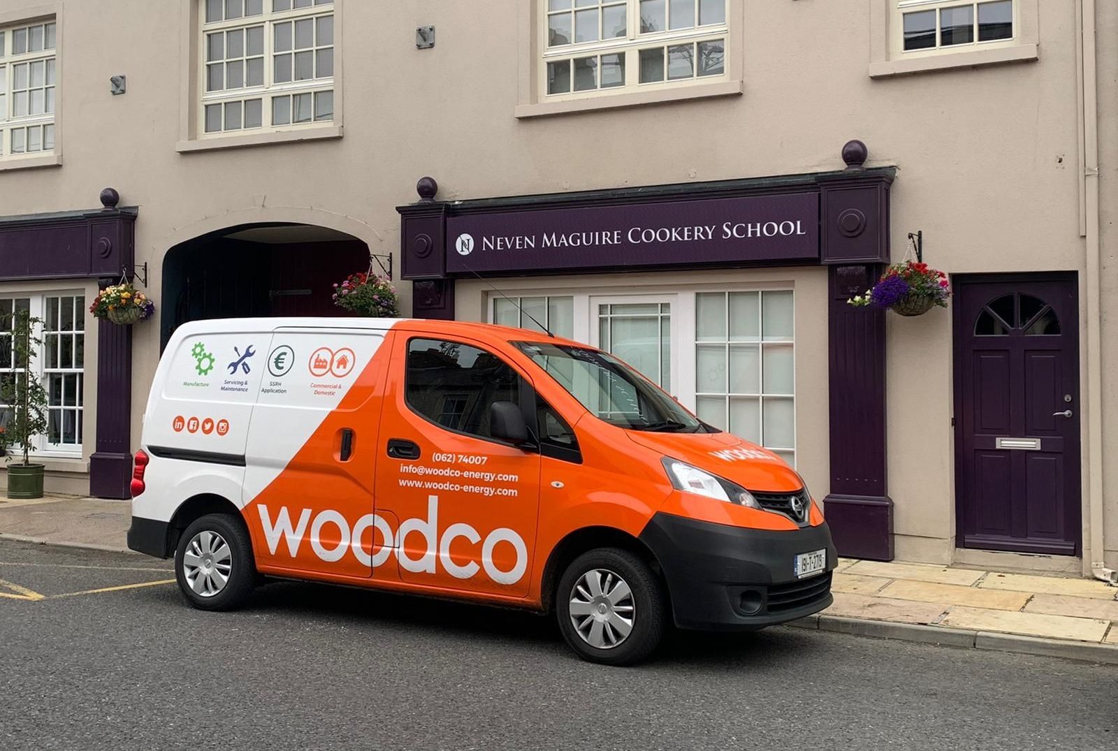 Fleet of service vehicles equipped for biomass system maintenance, including delivery trucks for fuel and specialized vans for servicing biomass boilers and heating systems
