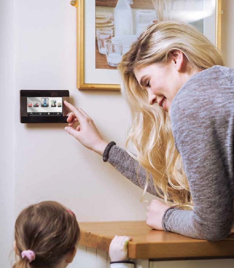 Close-up of a smart thermostat screen showing current home temperature, with remote access options via mobile device