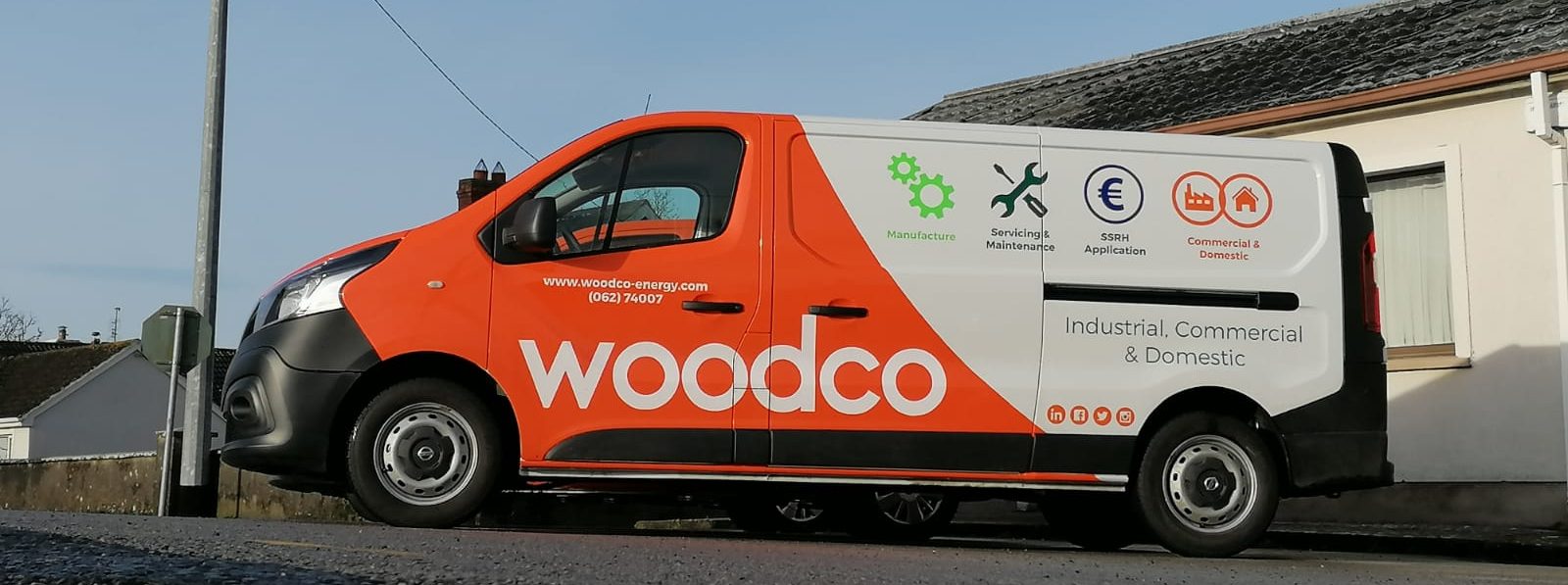 Fleet of service vehicles equipped for biomass system maintenance, including delivery trucks for fuel and specialized vans for servicing biomass boilers and heating systems